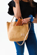 Woman holding natural Virginia leather small tote bag