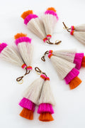 Four pairs of tassels in cream with vibrant pink and orange tips, displayed on a clean white background. Handmade by Meanwhile Back on the Farm in Lynchburg,VA