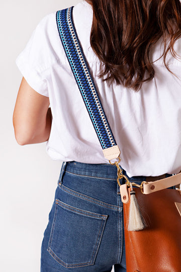 Girl wearing blue, white, and black patterned blue Italian webbing crossbody strap 