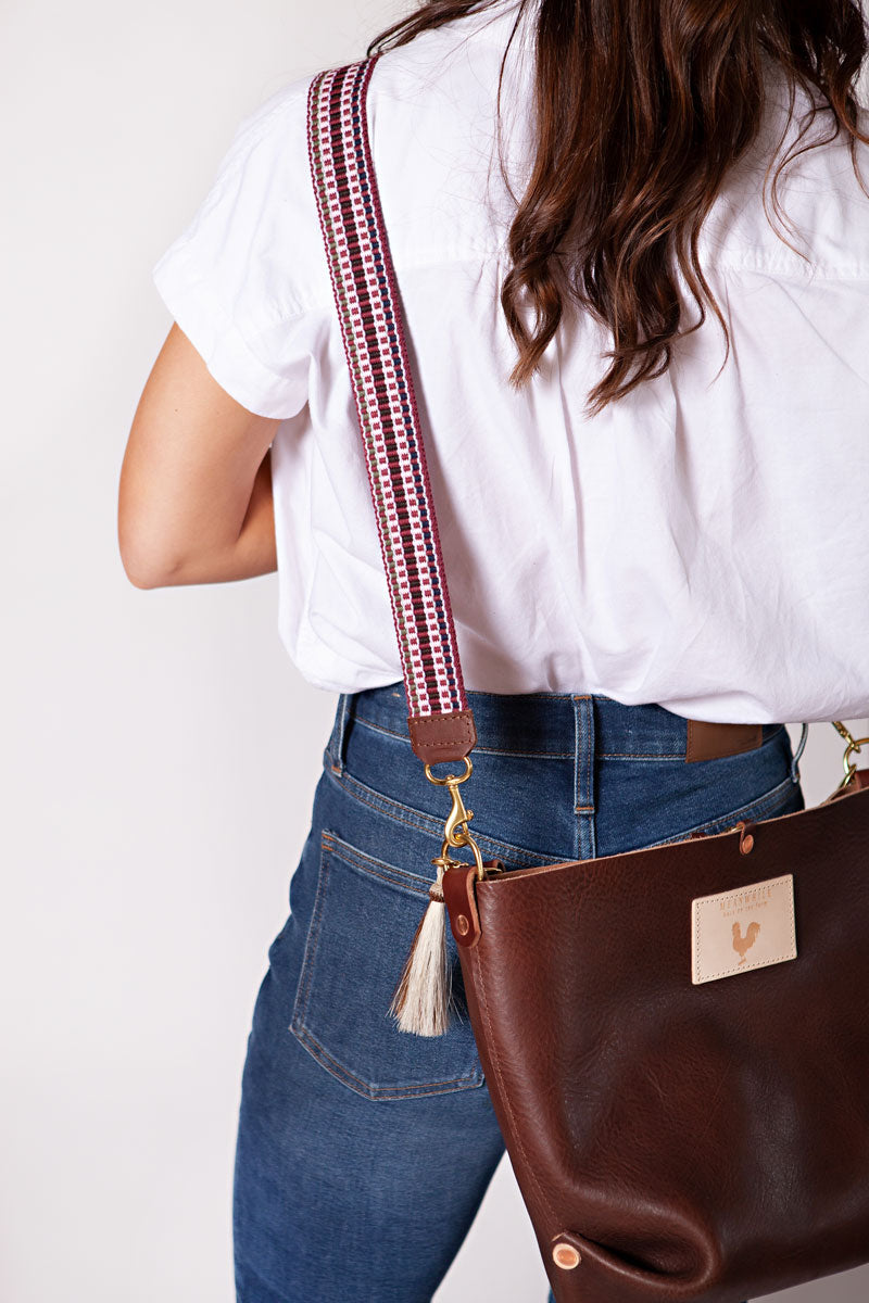 Girl wearing a brown leather bag with a Eggplant Italian Webbing Crossbody Strap