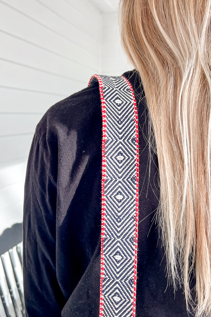Girl wearing an Americana webbing crossbody strap with a red and dark blue design pattern