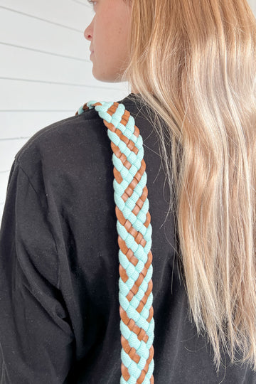 Girl wearing the aqua woven webbing crossbody strap with a brown and bright blue design
