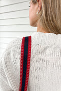 Girl wearing the patriot webbing crossbody strap with a red and navy blue striped design 