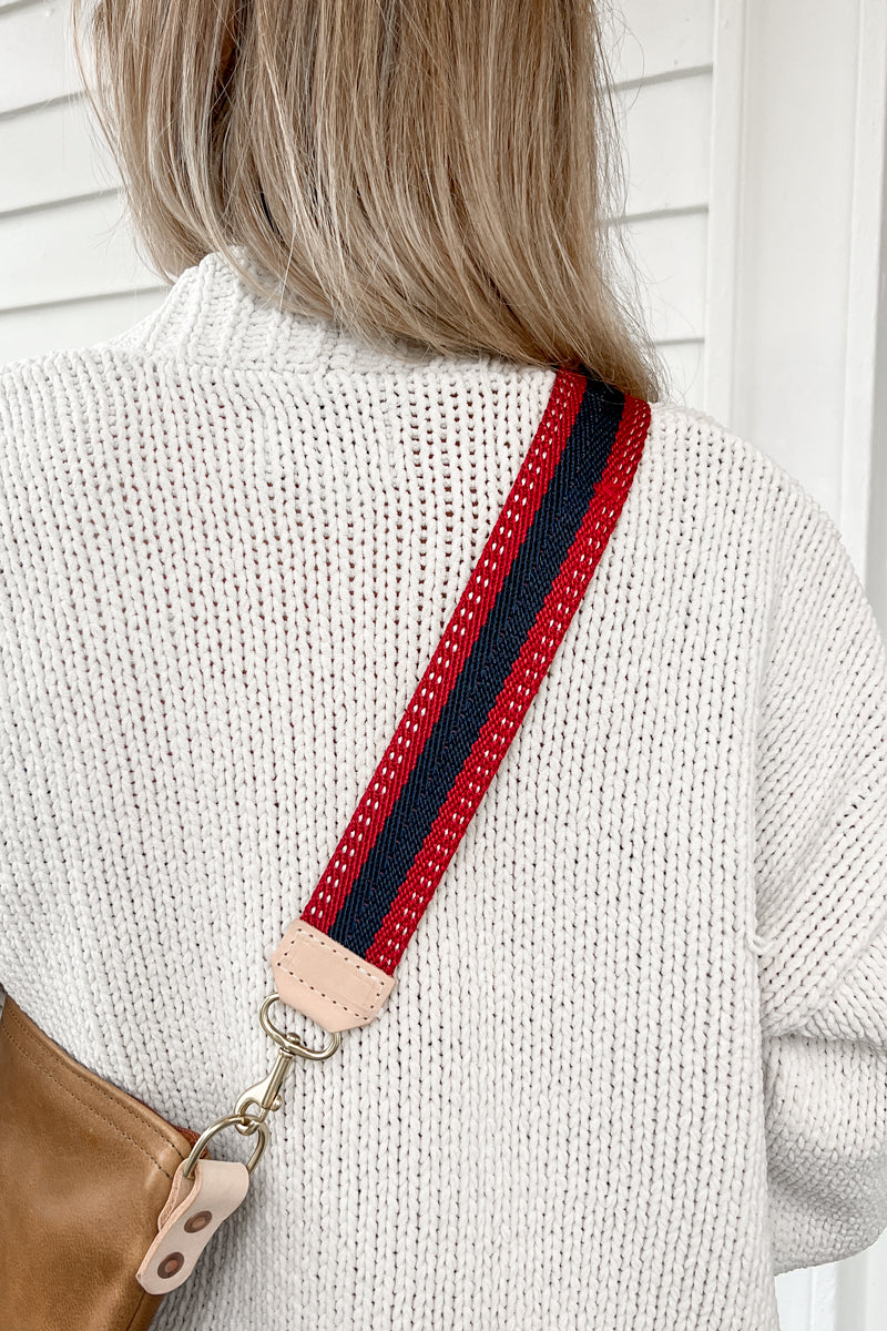 Girl wearing the patriot webbing crossbody strap with a red and navy blue striped design