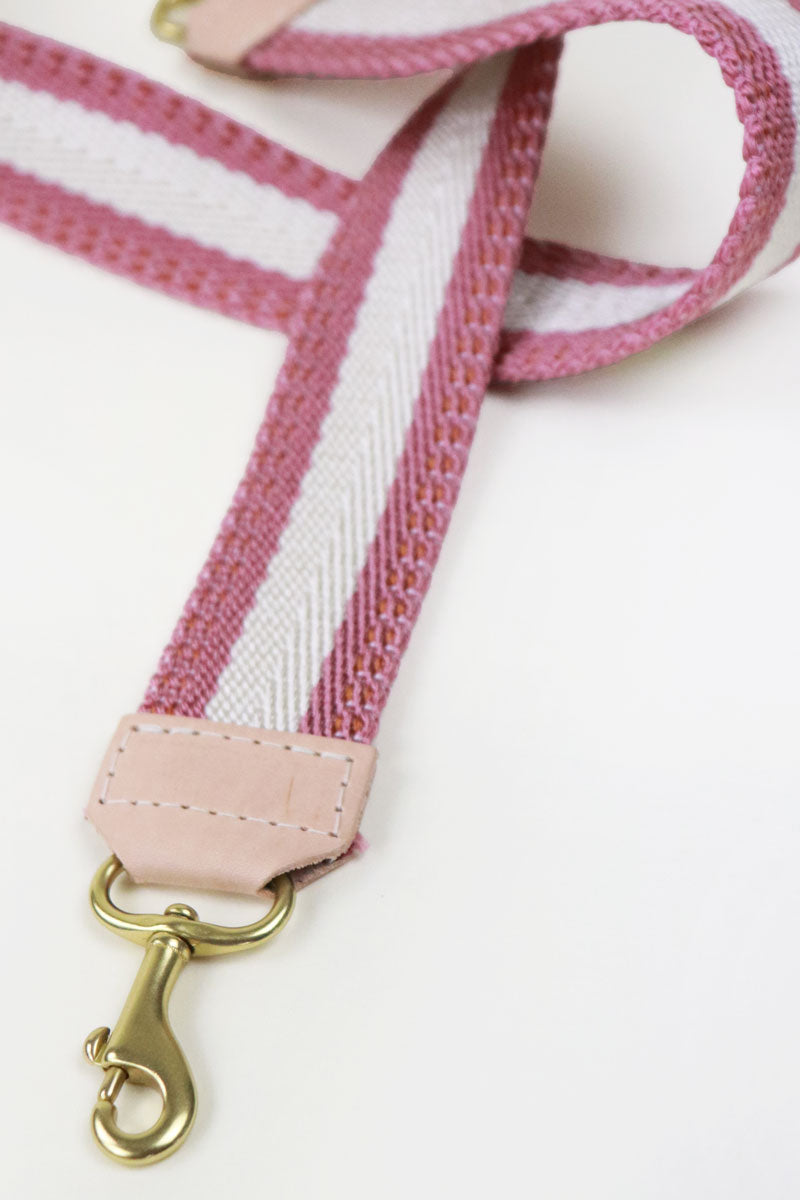 Girl wearing the rose webbing crossbody strap that has a pink and white stripe design