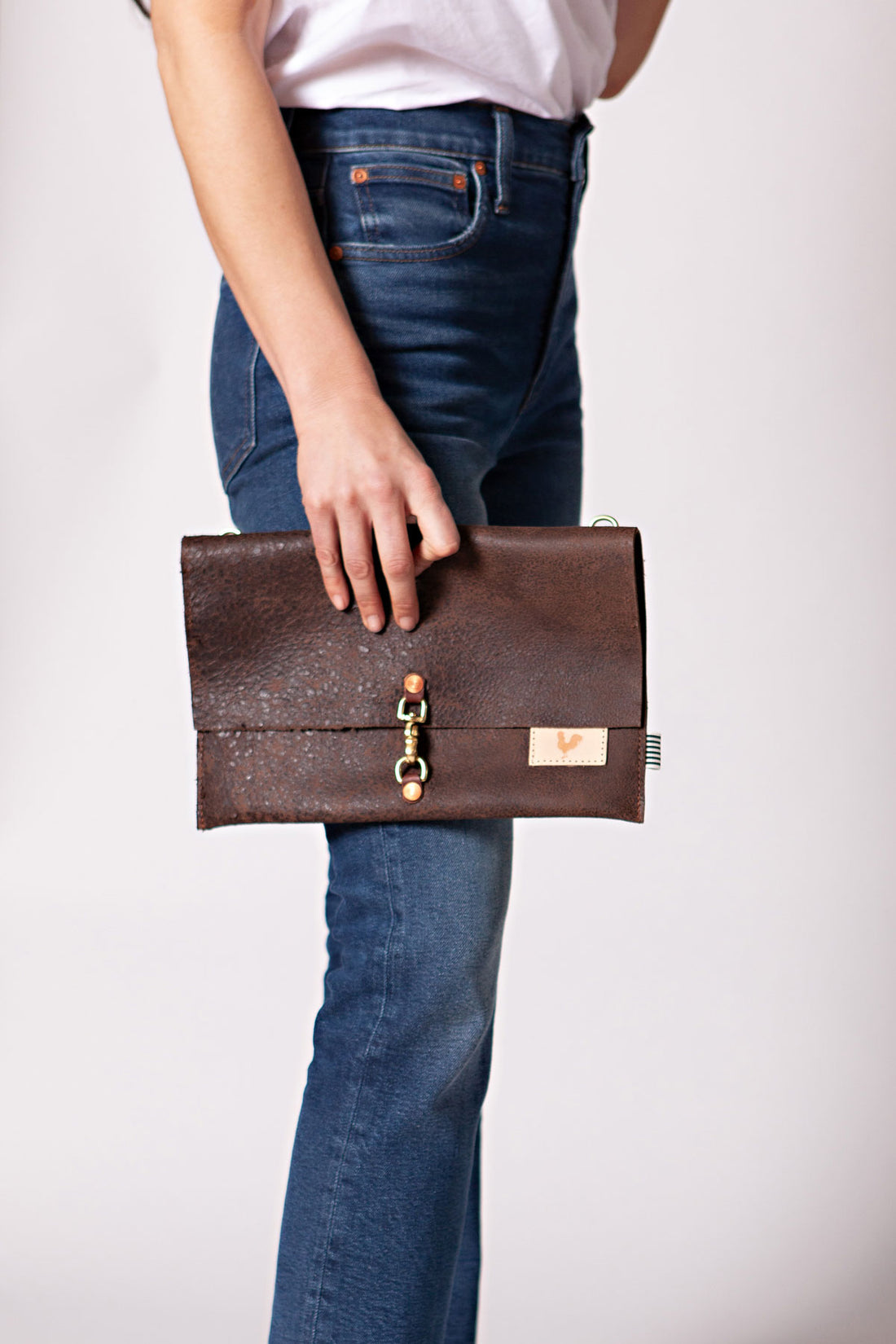 Woman wearing the birch mocha bag with meanwhile logo and cross body strap.